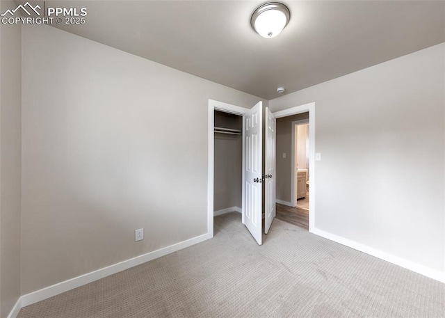 unfurnished bedroom featuring light carpet and a closet