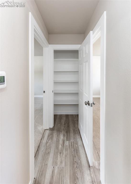 corridor with light hardwood / wood-style flooring