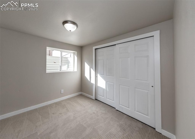 unfurnished bedroom featuring light carpet and a closet