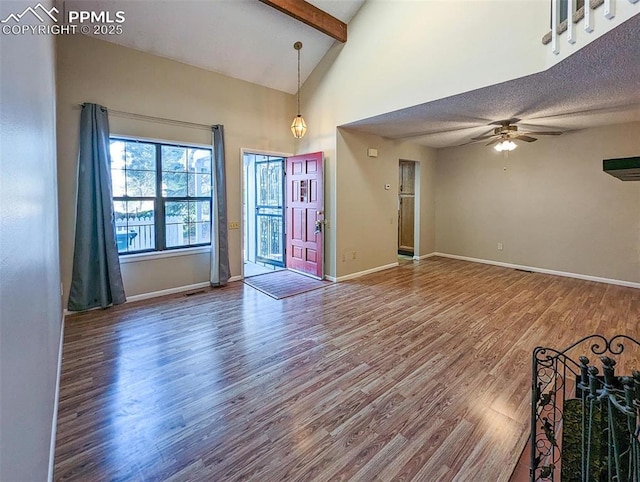 interior space featuring a textured ceiling, ceiling fan, beam ceiling, high vaulted ceiling, and hardwood / wood-style floors