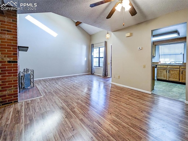 unfurnished living room with a textured ceiling, lofted ceiling, and hardwood / wood-style flooring