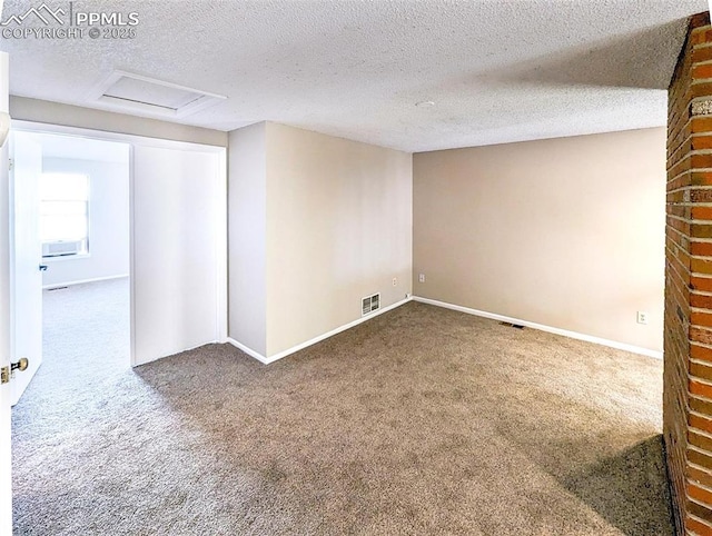 carpeted empty room featuring a textured ceiling