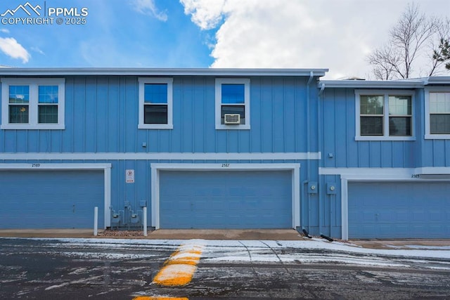 view of property with a garage and cooling unit