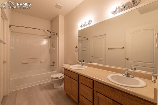 full bathroom with hardwood / wood-style floors, vanity, toilet, and washtub / shower combination