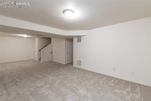 basement featuring a textured ceiling and light colored carpet