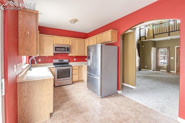 kitchen with sink, light colored carpet, stainless steel appliances, and light brown cabinets