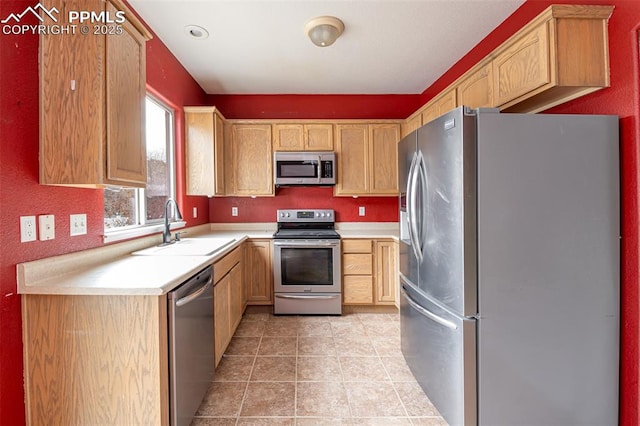 kitchen with light brown cabinetry, stainless steel appliances, light tile patterned floors, and sink