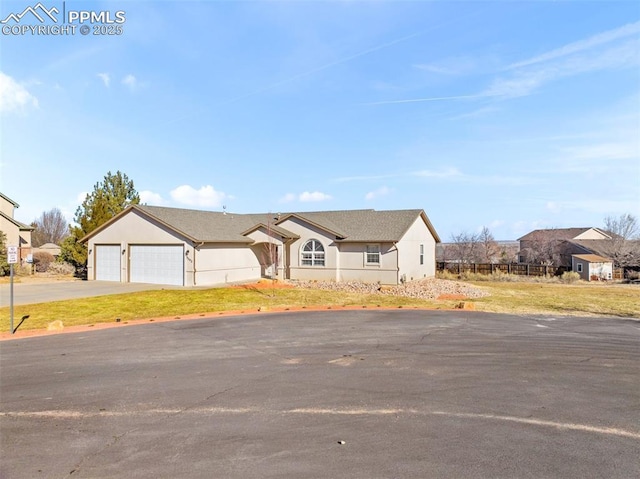 ranch-style house featuring a garage and a front lawn