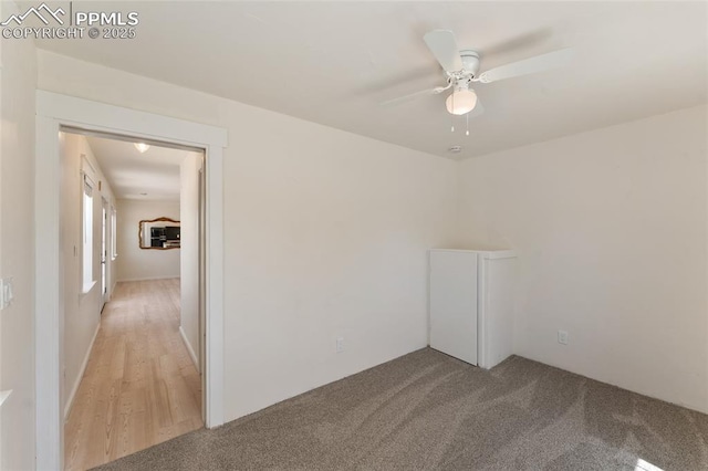 carpeted spare room with ceiling fan