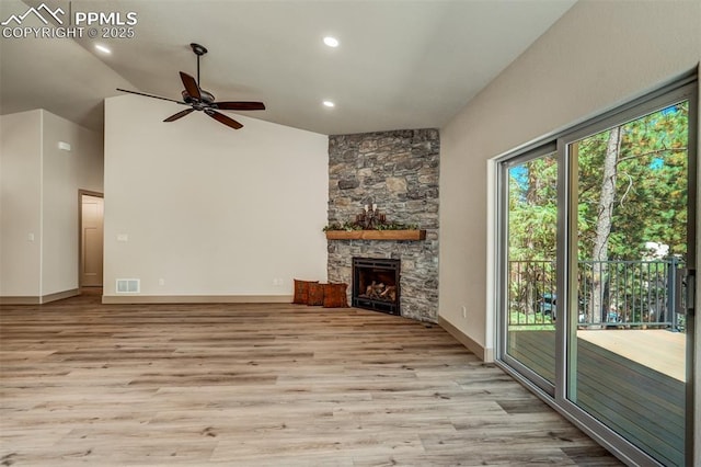 unfurnished living room featuring ceiling fan, light hardwood / wood-style floors, a fireplace, and vaulted ceiling