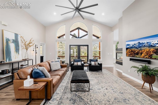 living room with french doors, ceiling fan, beam ceiling, hardwood / wood-style flooring, and high vaulted ceiling