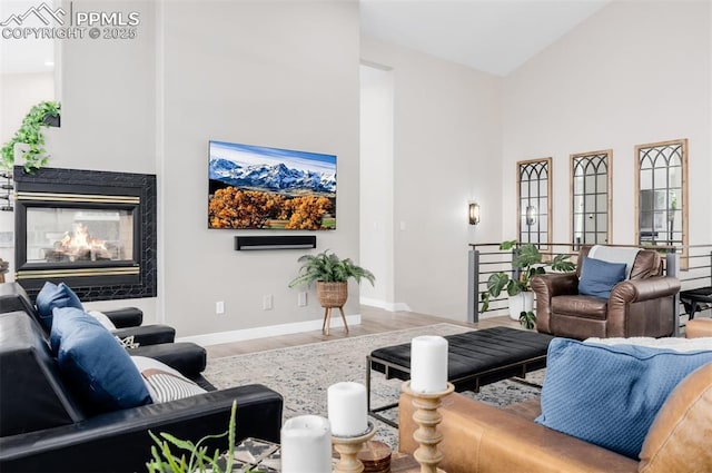 living room featuring a fireplace, hardwood / wood-style floors, and high vaulted ceiling