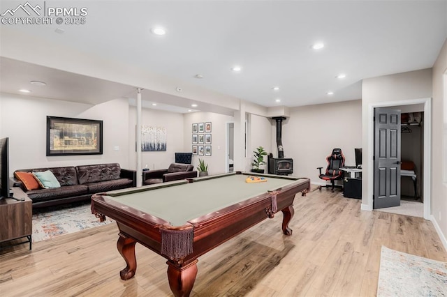 game room featuring a wood stove, billiards, and light hardwood / wood-style flooring