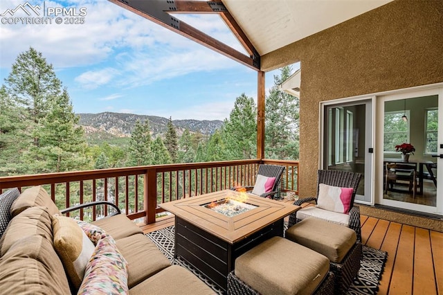 deck featuring a mountain view and an outdoor fire pit