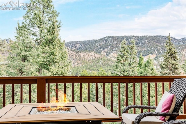 deck featuring a mountain view and a fire pit