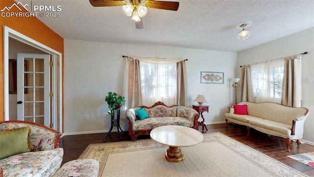 living room featuring dark hardwood / wood-style flooring, a textured ceiling, and plenty of natural light