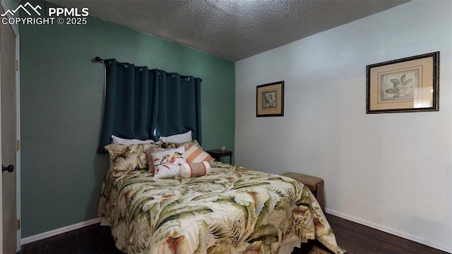 bedroom with a textured ceiling and dark wood-type flooring