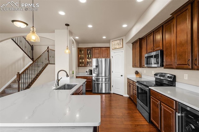 kitchen featuring appliances with stainless steel finishes, dark hardwood / wood-style flooring, beverage cooler, sink, and decorative light fixtures