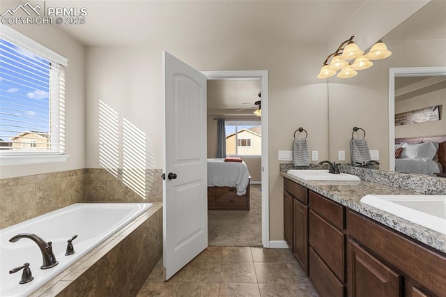 bathroom with ceiling fan, a relaxing tiled tub, vanity, and a wealth of natural light