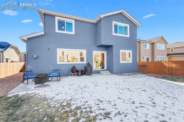 snow covered rear of property featuring a patio area