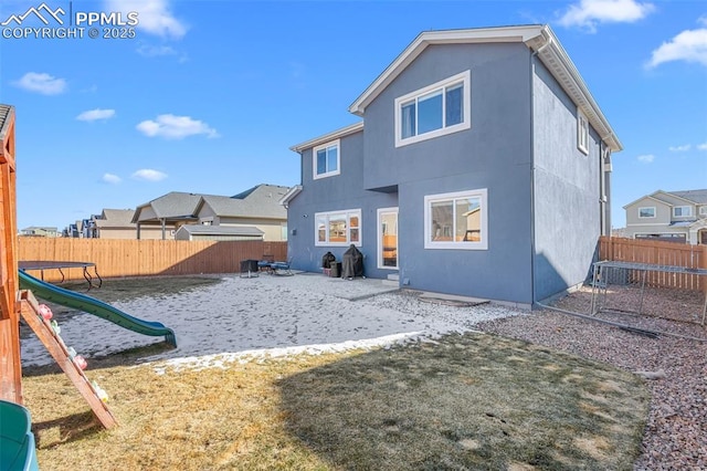 back of property featuring a playground and a yard