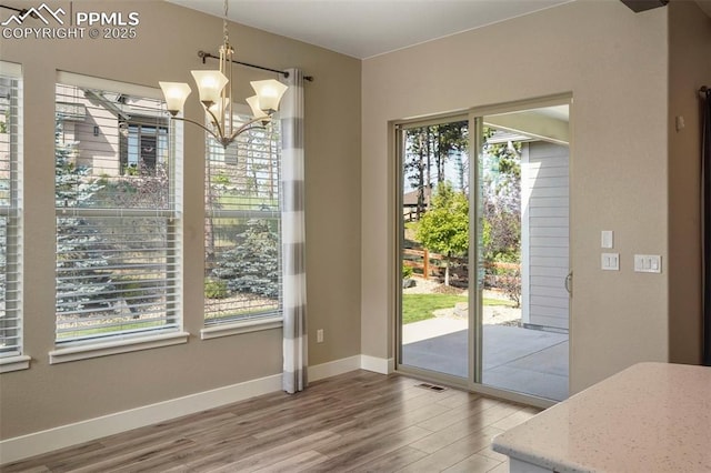 doorway with hardwood / wood-style flooring and a chandelier