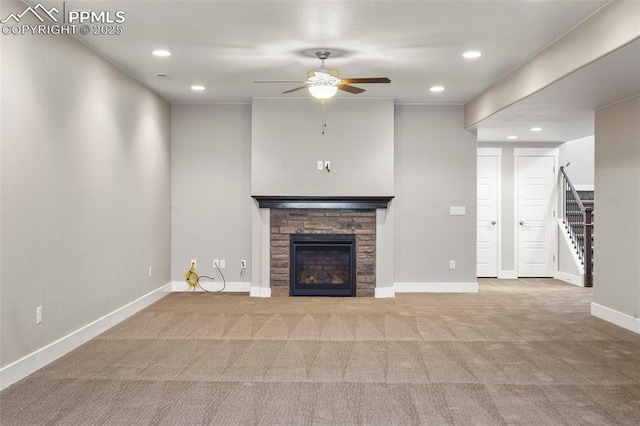 unfurnished living room featuring ceiling fan, light colored carpet, and a fireplace