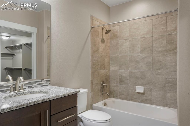 full bathroom featuring backsplash, vanity, tiled shower / bath combo, and toilet