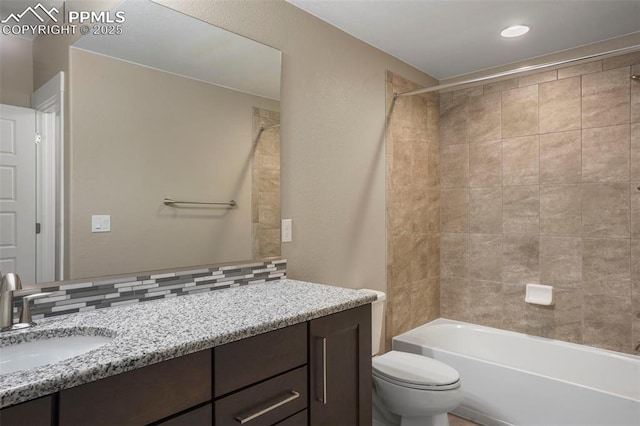 full bathroom with backsplash, toilet, vanity, and tiled shower / bath