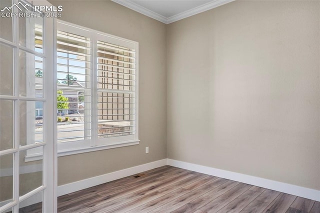 empty room with hardwood / wood-style flooring and ornamental molding