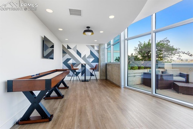 interior space with floor to ceiling windows and wood-type flooring