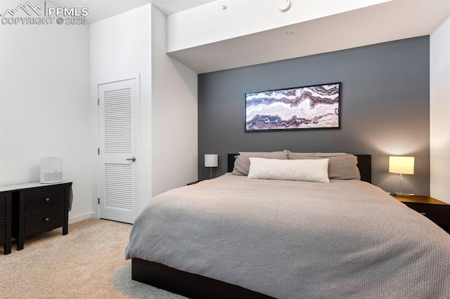 bedroom featuring light carpet and a closet