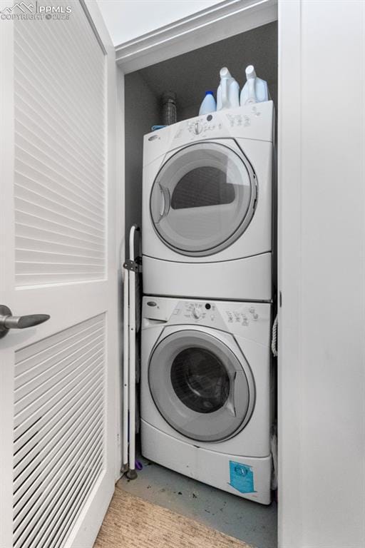 clothes washing area featuring stacked washer and clothes dryer