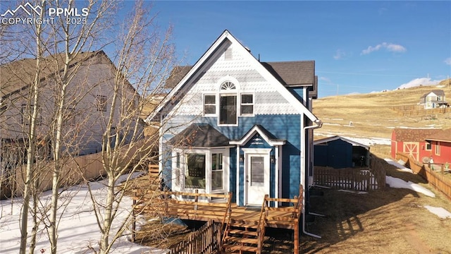 view of front of property with a storage unit and a deck