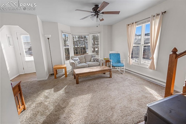 sitting room featuring carpet flooring, ceiling fan, and a baseboard radiator