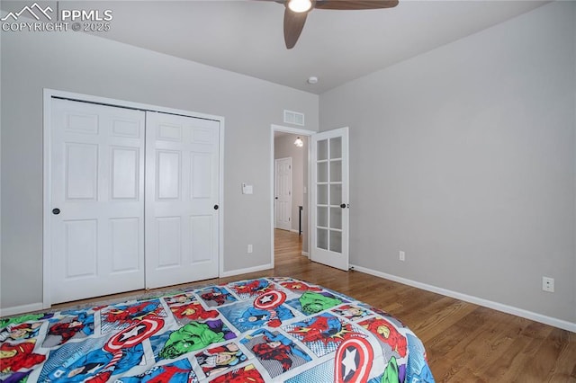 bedroom with hardwood / wood-style floors, ceiling fan, french doors, and a closet