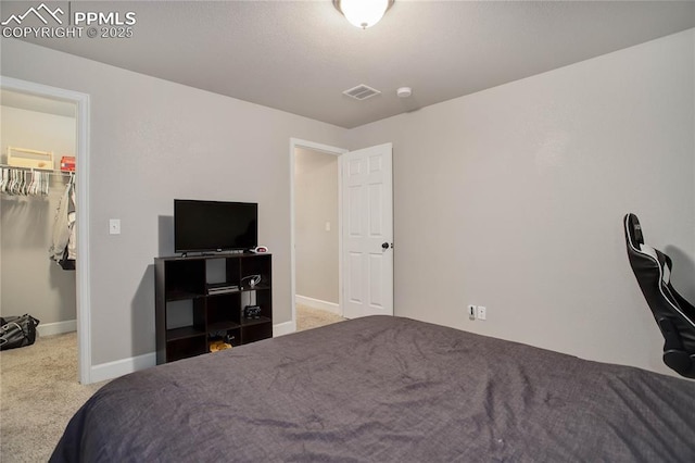 bedroom featuring carpet floors, a spacious closet, and a closet