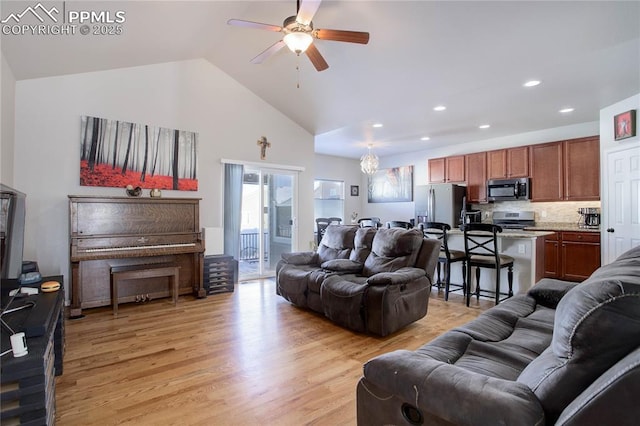 living room with light wood-type flooring, high vaulted ceiling, and ceiling fan