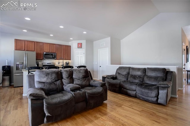 living room featuring light hardwood / wood-style floors and vaulted ceiling