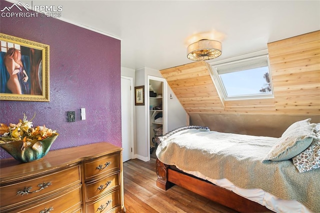 bedroom with light wood-type flooring and lofted ceiling with skylight