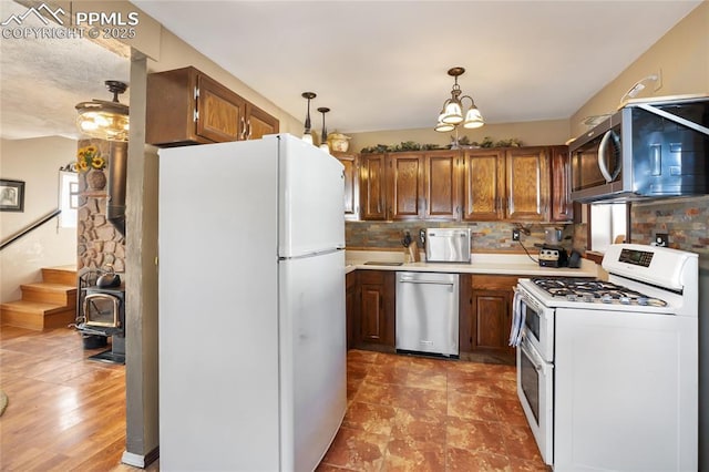 kitchen with stainless steel appliances, a chandelier, tasteful backsplash, and hanging light fixtures