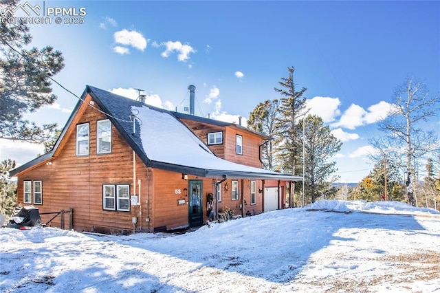 snow covered back of property featuring a porch