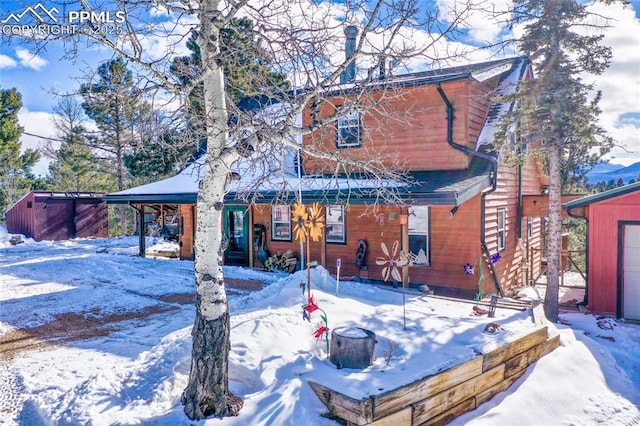 view of snow covered rear of property