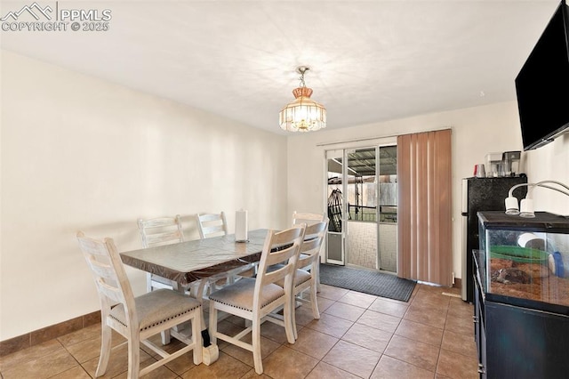 dining area featuring tile patterned flooring and an inviting chandelier