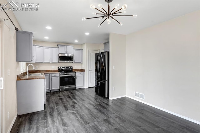 kitchen with gray cabinets, sink, stainless steel appliances, and wood counters