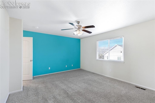 carpeted spare room featuring ceiling fan