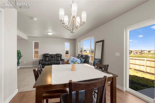 dining room with light hardwood / wood-style flooring and an inviting chandelier