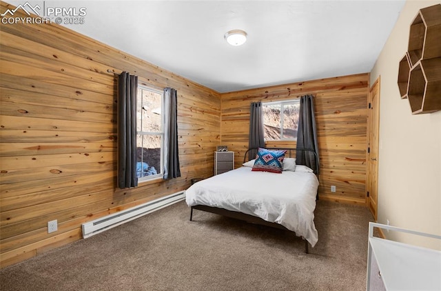 bedroom with carpet, wooden walls, and a baseboard heating unit