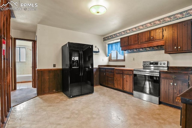 kitchen with black fridge and stainless steel range with electric cooktop