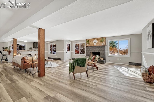 living room with light wood-type flooring and a brick fireplace